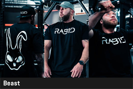 Man wearing a black 'RABID' oversize t-shirt with a logo, standing in a gym setting.